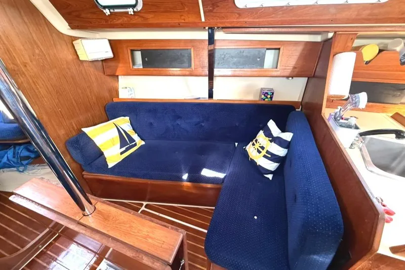 Slide: The Image of Interior of 1986 Pearson 33-2 sailboat with blue seating and nautical-themed pillows. - 19