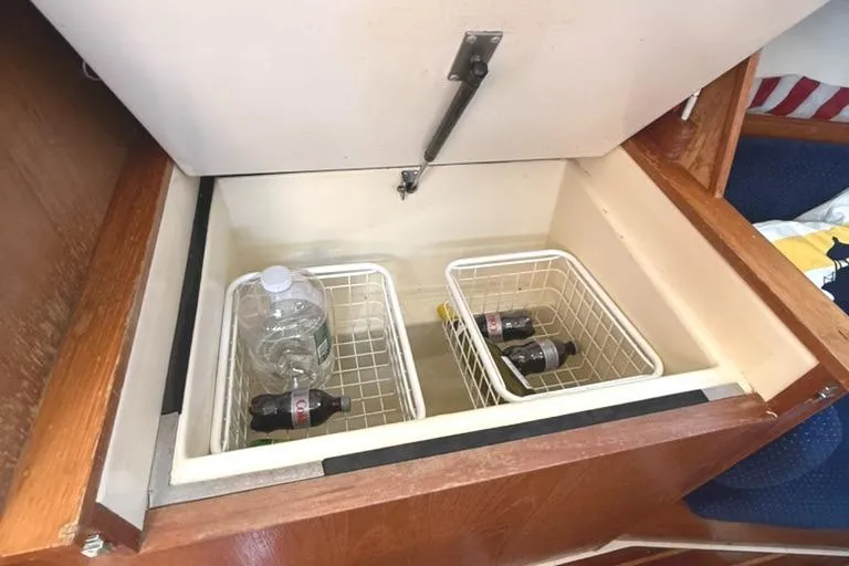 Slide: The Image of Open storage compartment on a 1986 Pearson 33-2 boat with drinks in baskets. - 23