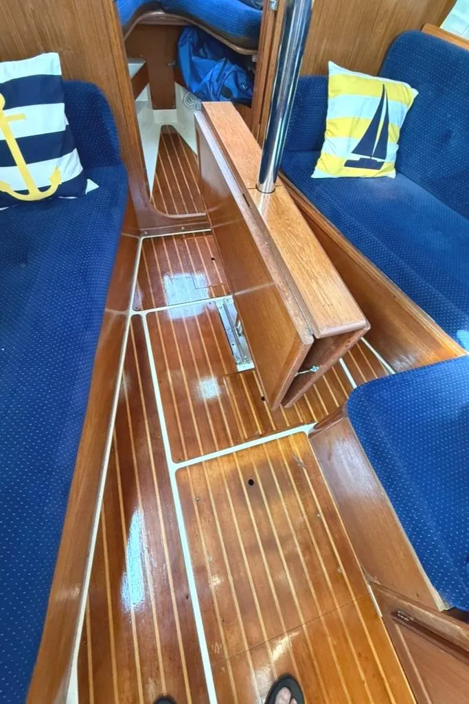 Slide: The Image of Interior of a 1986 Pearson 33-2 sailboat with polished wood flooring and blue seating. - 28