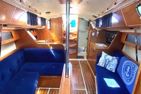 Slide: The Image of Interior of a 1986 Pearson 33-2 sailboat with blue seating and wooden finishes. - 4