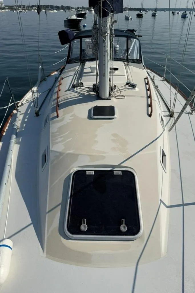 Slide: The Image of 1986 Pearson 33-2 sailboat deck with hatch, docked in calm waters. - 6