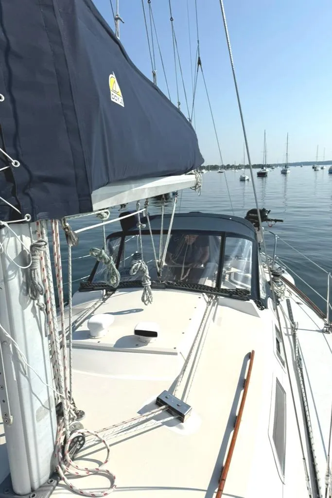 Slide: The Image of 1986 Pearson 33-2 sailboat on calm water, featuring a blue sail cover and clear sky. - 7