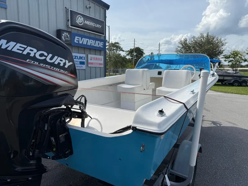 Slide: The Image of 1963 T Craft VHULL boat with Mercury FourStroke engine, parked near dealership signs. - 10