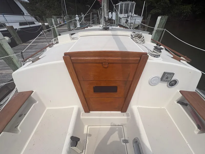 Slide: The Image of 1986 Island Packet IP27 Cutter sailboat cockpit with wooden hatch and dock view. - 12