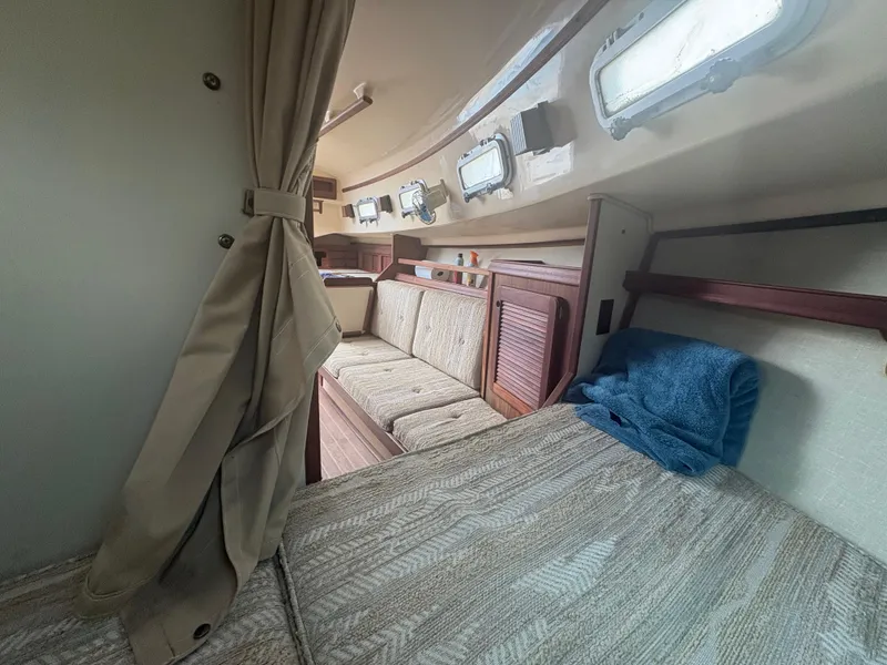 Slide: The Image of Interior of 1986 Island Packet IP27 Cutter, featuring cozy seating and nautical decor. - 17