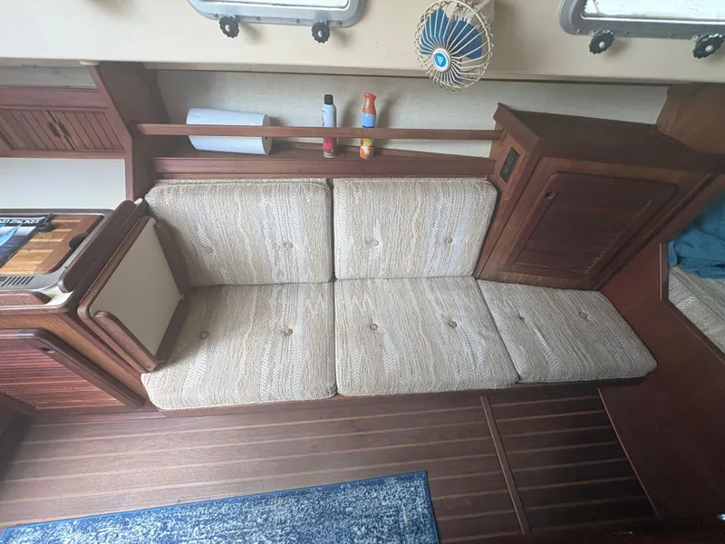 Slide: The Image of Interior of 1986 Island Packet IP27 Cutter with cushioned seating and wooden cabinetry. - 19