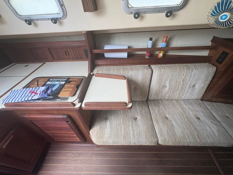 Slide: The Image of Interior of 1986 Island Packet IP27 Cutter with cozy seating and wooden accents. - 20