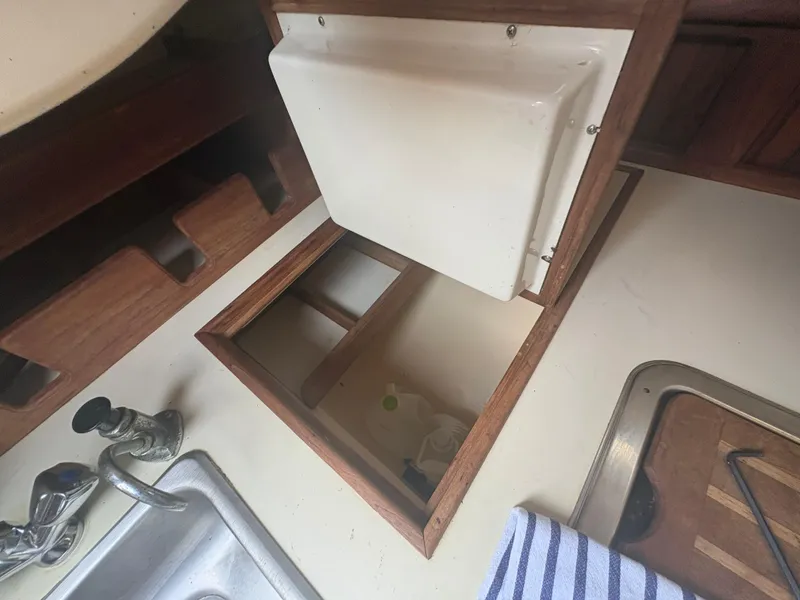 Slide: The Image of Interior of 1986 Island Packet IP27 Cutter showing sink, storage, and wooden cabinetry. - 22