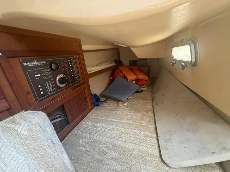 Slide: The Image of Interior of 1986 Island Packet IP27 Cutter, featuring control panel and storage area. - 25