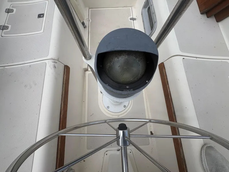 Slide: The Image of Steering wheel and compass on 1986 Island Packet IP27 Cutter sailboat. - 33