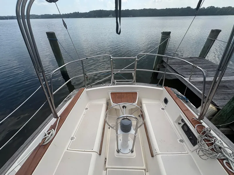 Slide: The Image of 1986 Island Packet IP27 Cutter sailboat cockpit at dock, overlooking calm water. - 6