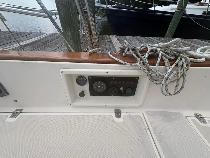 Slide: The Image of 1986 Island Packet IP27 Cutter cockpit with control panel and coiled ropes. - 8