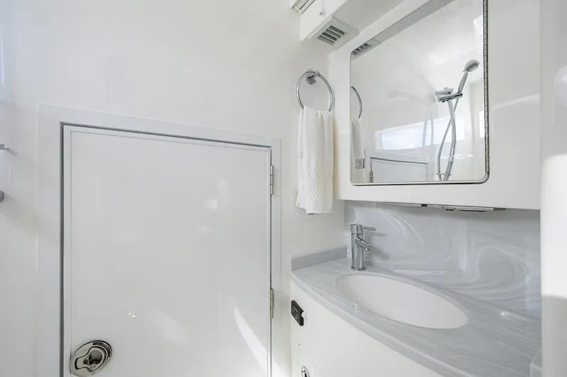 Slide: The Image of 2026 Valhalla Boatworks V-46 bathroom with modern sink, mirror, and towel holder. - 21