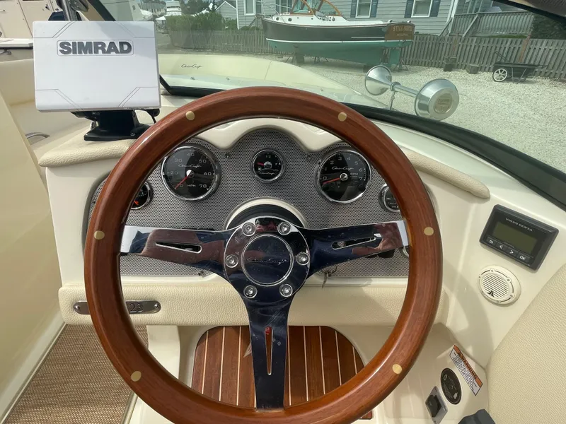 Slide: The Image of 2020 Chris-Craft Launch 23 dashboard with wooden steering wheel and Simrad display. - 15