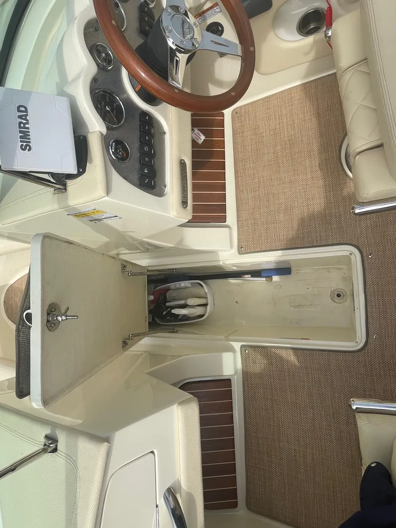 Slide: The Image of 2020 Chris-Craft Launch 23 boat interior with steering wheel, dashboard, and storage compartment. - 19