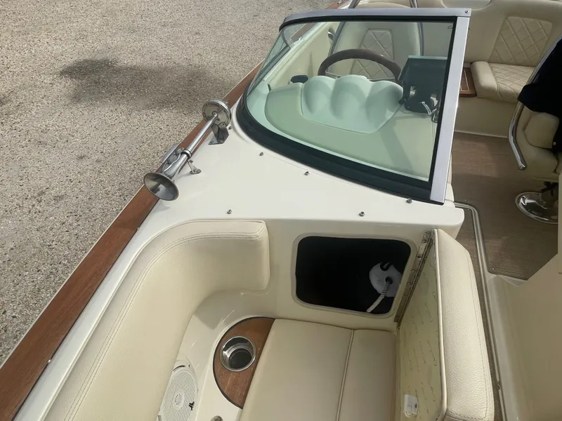 Slide: The Image of 2020 Chris-Craft Launch 23 boat interior with beige seating and wooden accents. - 22
