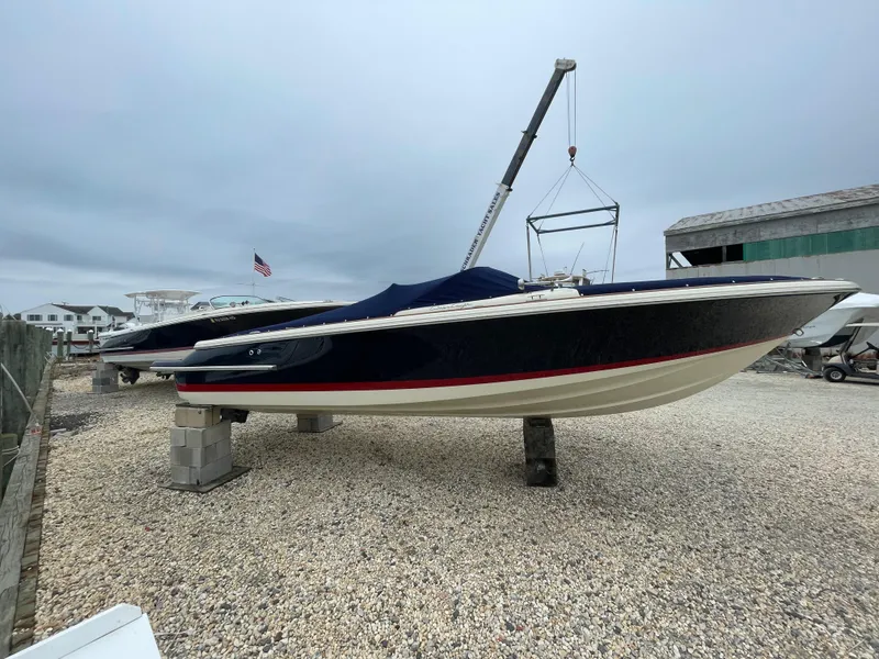 Slide: The Image of 2020 Chris-Craft Launch 23 boat on dry dock, covered, with overcast sky. - 29