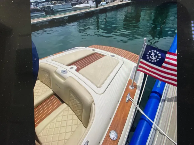 Slide: The Image of 2020 Chris-Craft Launch 23 boat docked, featuring elegant seating and nautical flag. - 3