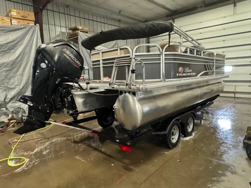 Slide: The Image of 2023 Sun Tracker Party Barge 20 DLX pontoon boat in a garage setting. - 3