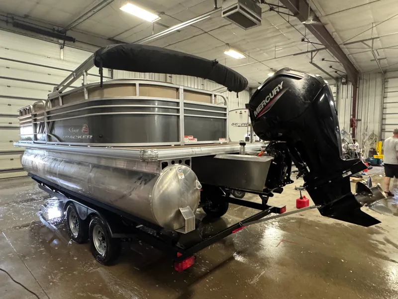 Slide: The Image of 2023 Sun Tracker Party Barge 20 DLX pontoon boat with Mercury outboard motor in a garage. - 4