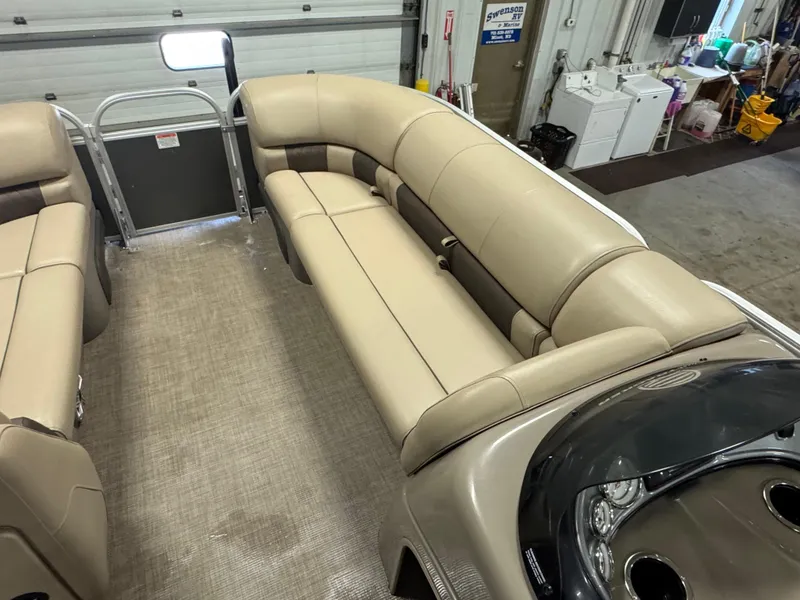 Slide: The Image of 2023 Sun Tracker Party Barge 20 DLX interior with beige seating and dashboard. - 6