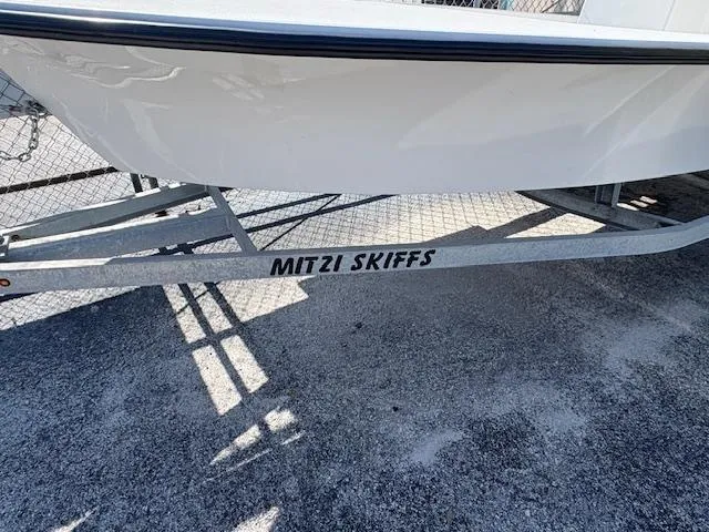 Slide: The Image of 2025 Mitzi Skiff 15 boat on trailer, displayed outdoors. - 10