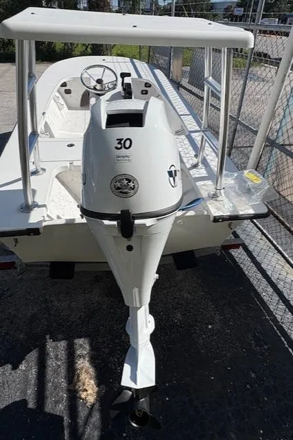 Slide: The Image of 2025 Mitzi Skiff 15 boat with 30 HP outboard motor, parked on a trailer. - 3