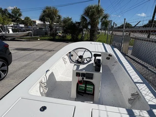Slide: The Image of 2025 Mitzi Skiff 15 boat interior with steering wheel and control panel in a sunny outdoor setting. - 8