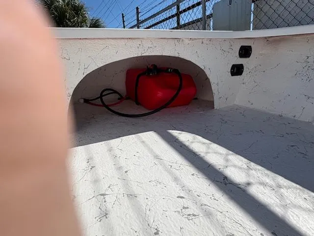 Slide: The Image of 2025 Mitzi Skiff 15 interior with red fuel tank and textured flooring. - 9