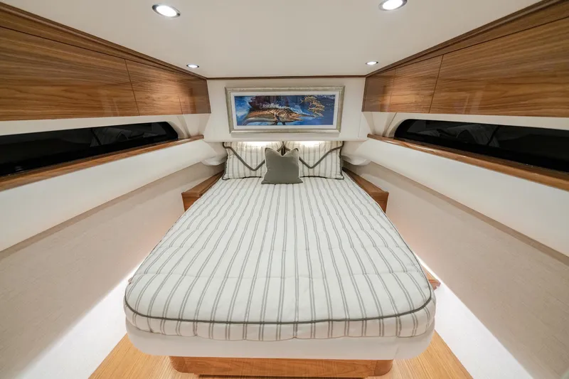 Slide: The Image of Luxurious cabin interior of 2026 Valhalla Boatworks V-55 with striped bedding and wood accents. - 6