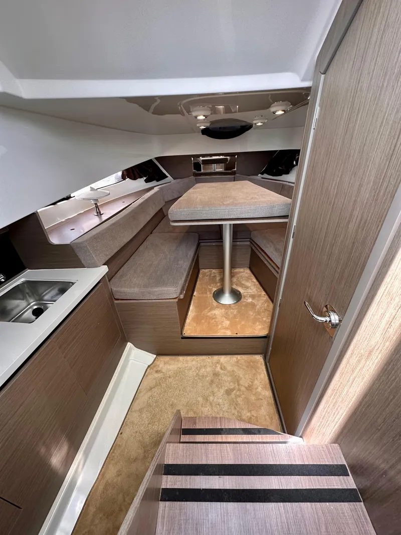 Slide: The Image of 2023 Beneteau Flyer 9 SUNdeck interior with seating, table, and kitchenette. - 18