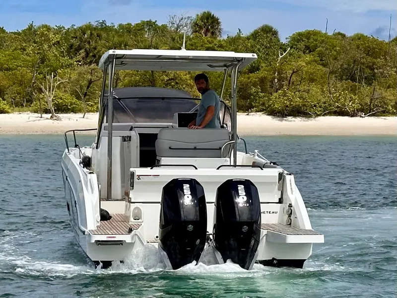 Slide: The Image of 2023 Beneteau Flyer 9 SUNdeck boat cruising near a sandy beach. - 2