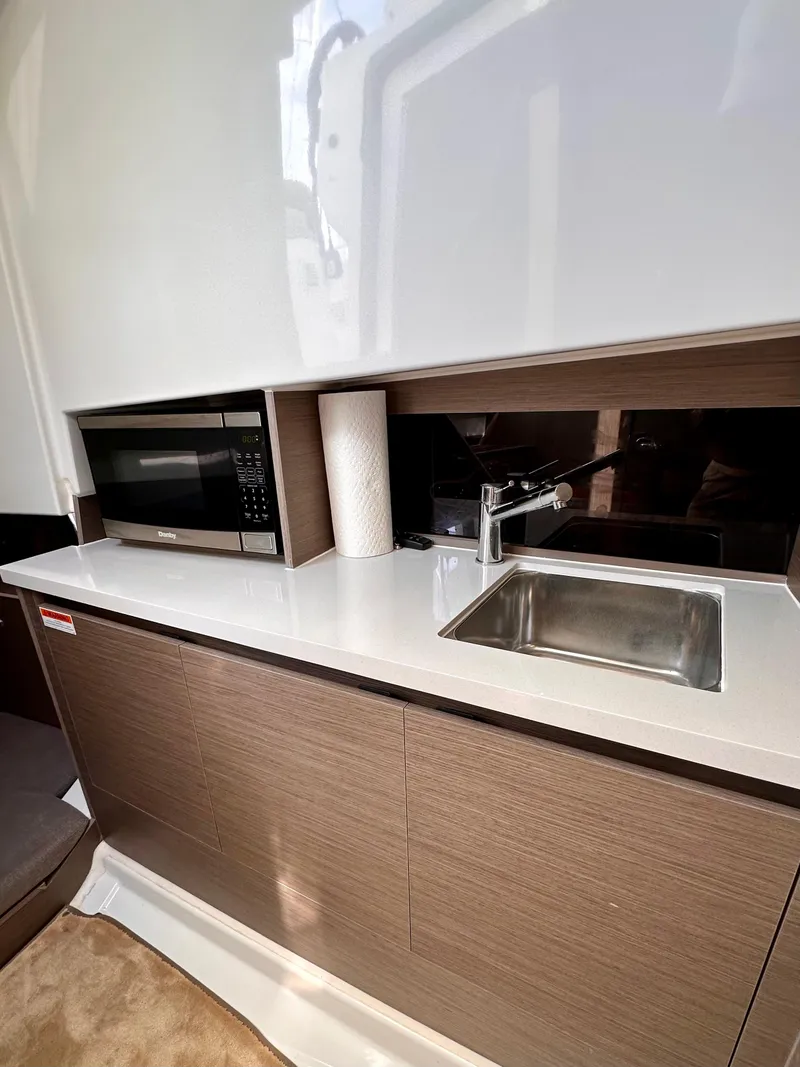 Slide: The Image of 2023 Beneteau Flyer 9 SUNdeck kitchen with microwave, sink, and modern cabinetry. - 20