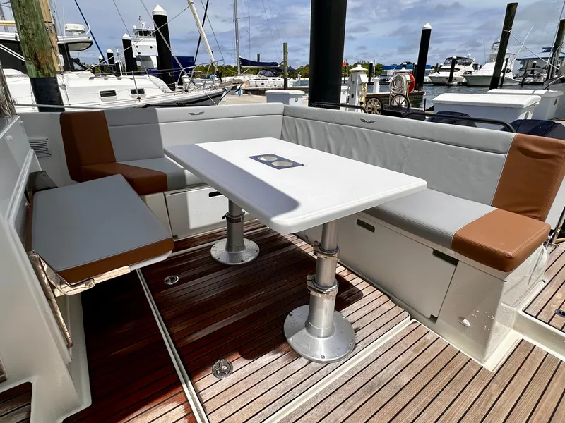 Slide: The Image of 2023 Beneteau Flyer 9 SUNdeck boat interior with seating and table at marina. - 9