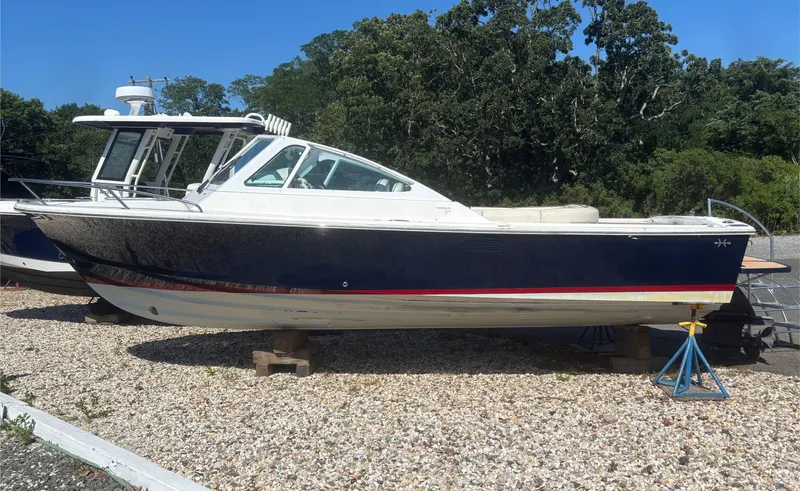 Slide: The Image of 2015 Hunt Yachts Harrier 25 Sport boat on gravel, surrounded by trees. - 7