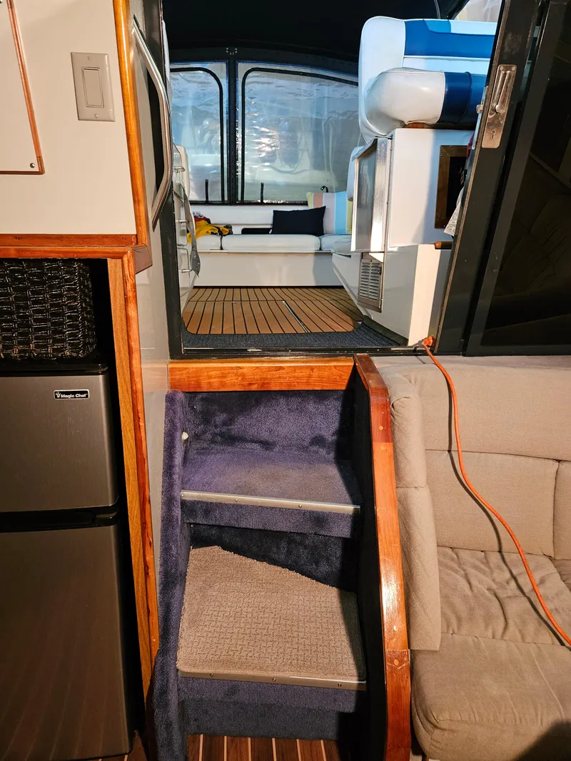 Slide: The Image of Interior view of 1989 Sea Ray 390 Express yacht with stairs and seating area. - 15