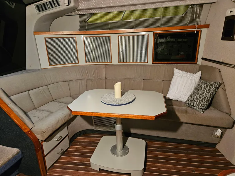 Slide: The Image of Interior of 1989 Sea Ray 390 Express with cozy seating and table. - 16