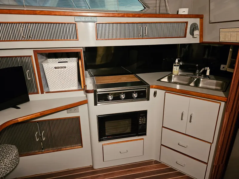 Slide: The Image of 1989 Sea Ray 390 Express yacht kitchen with stove, microwave, and sink. - 18