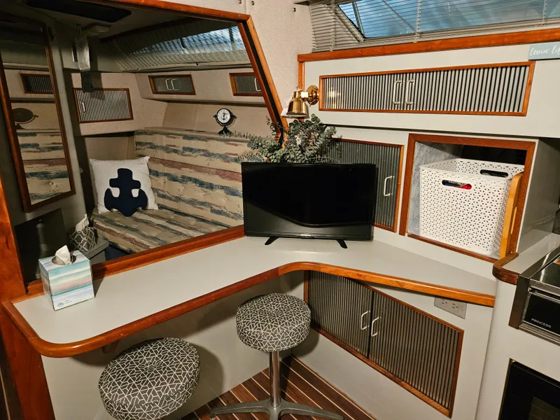 Slide: The Image of Interior of 1989 Sea Ray 390 Express with seating, TV, and nautical decor. - 19