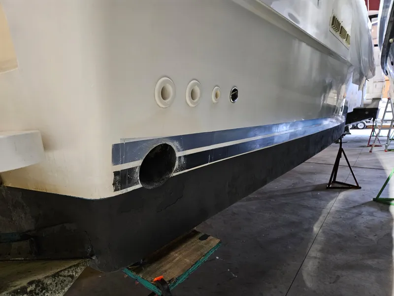 Slide: The Image of 1989 Sea Ray 390 Express boat hull in a workshop setting. - 26