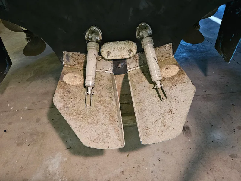 Slide: The Image of 1989 Sea Ray 390 Express boat trim tabs and propellers in a garage. - 28