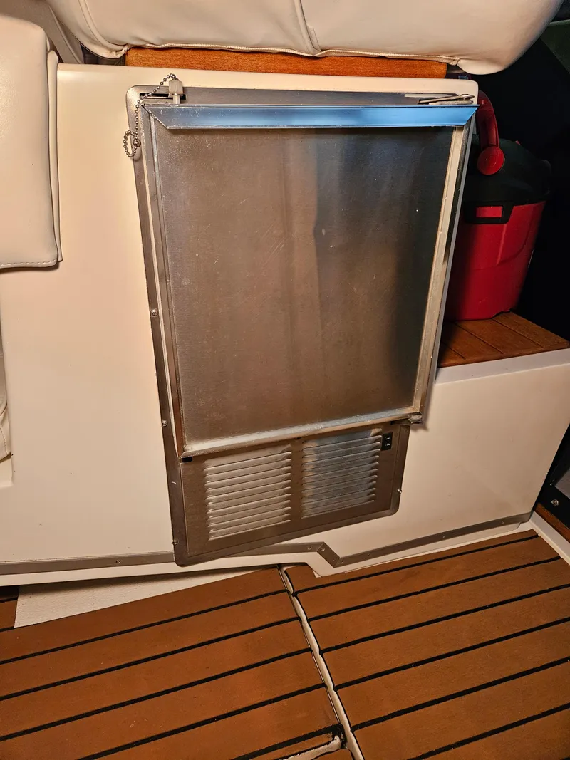 Slide: The Image of 1989 Sea Ray 390 Express interior with stainless steel fridge and wooden flooring. - 29
