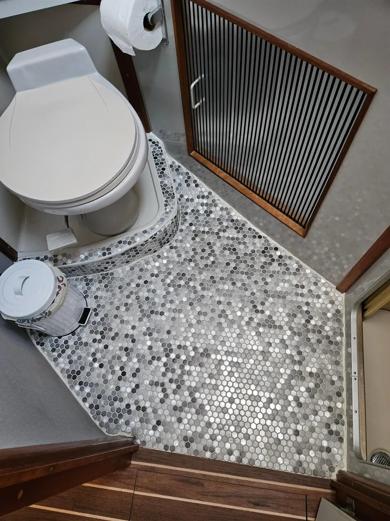 Slide: The Image of 1989 Sea Ray 390 Express bathroom with mosaic tile floor and modern fixtures. - 31