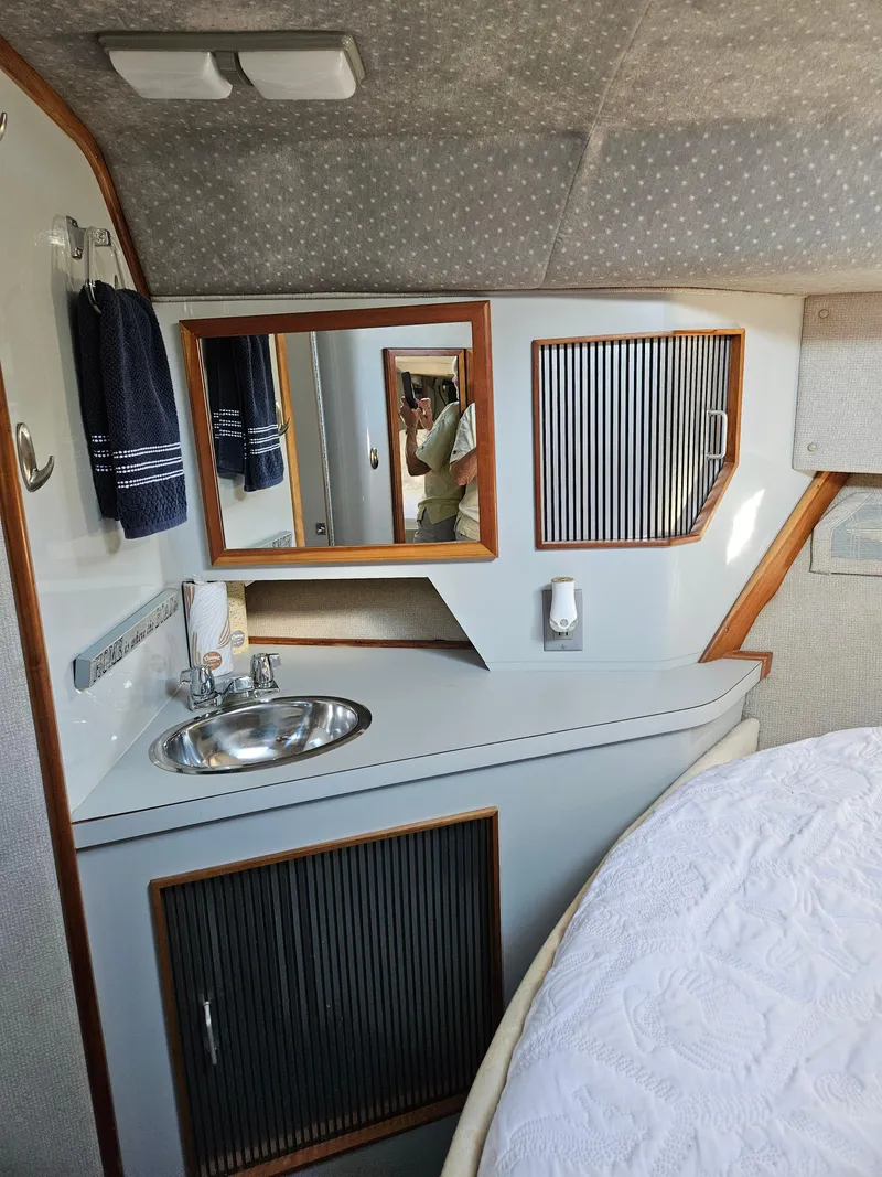 Slide: The Image of 1989 Sea Ray 390 Express cabin interior with sink and mirror. - 32