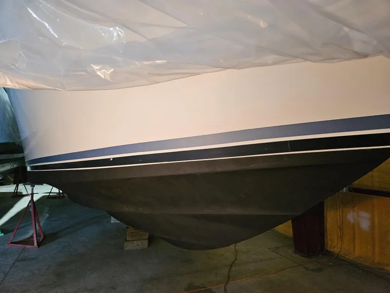 Slide: The Image of 1989 Sea Ray 390 Express boat hull in storage, partially covered. - 35