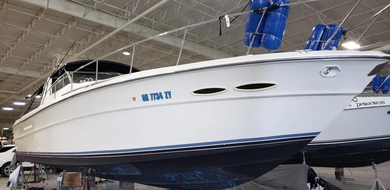 Slide: The Image of 1989 Sea Ray 390 Express boat in indoor storage with blue fenders. - 5