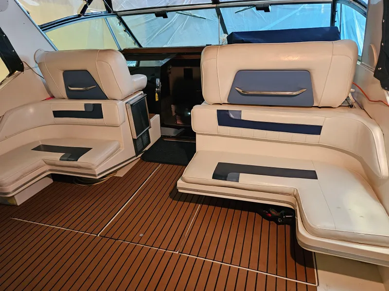 Slide: The Image of 1989 Sea Ray 390 Express interior with beige seating and wood flooring. - 6