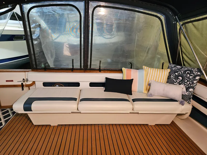 Slide: The Image of Interior of 1989 Sea Ray 390 Express with cushioned seating and decorative pillows. - 7