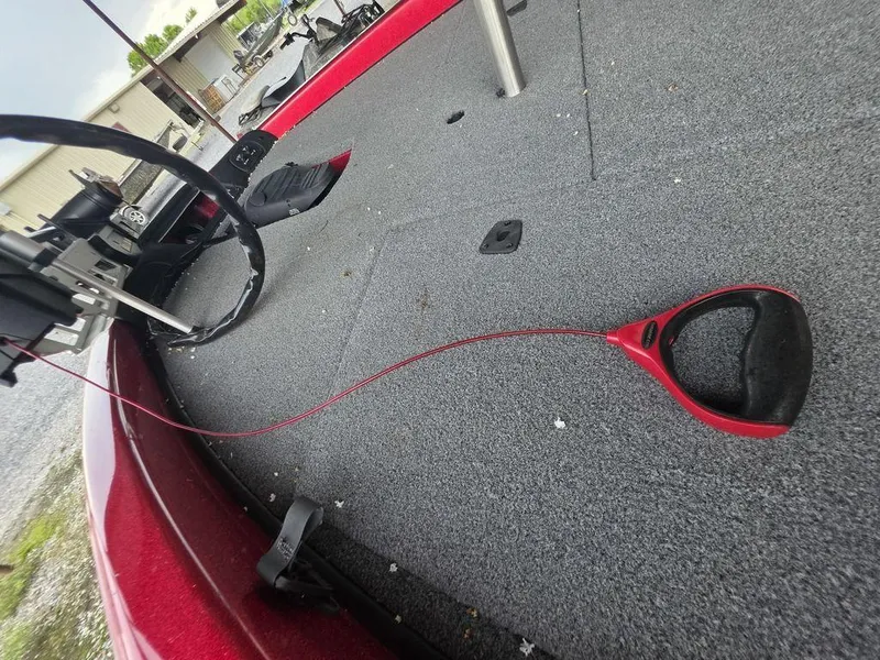 Slide: The Image of Open storage compartment in 2018 Phoenix 819 Pro boat, featuring red trim and hydraulic support. - 13
