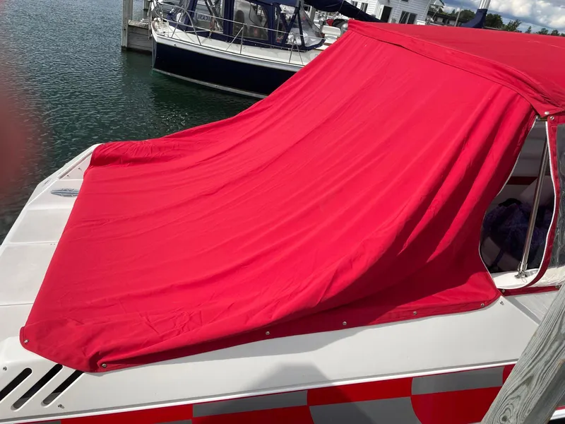 Slide: The Image of 1995 Fountain 38 Sport Cruiser with red cover docked at marina. - 10